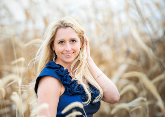 blonde woman wearing blue posing for portrait